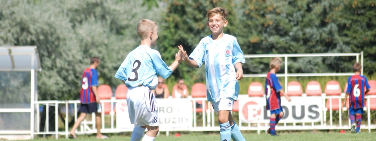 Two young players high-fiving on the field